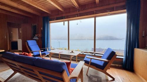 a living room with a couch and chairs and a table at Idyllic Vacation Home with a Breathtaking View in Bøur