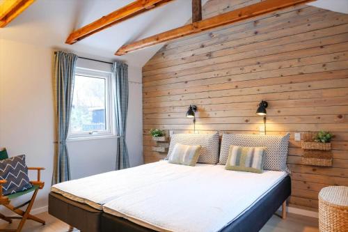 a bed in a room with a wooden wall at 13345-1-Vig-Poppelvej-21 in Vig