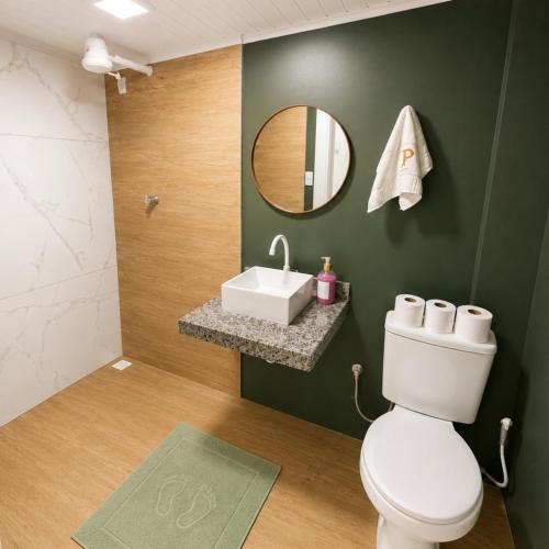 a bathroom with a white toilet and a sink at Hotel Presidente Ibirubá in Ibirubá