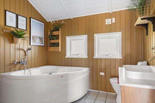 a bathroom with a tub and a toilet and a sink at 2556-Romo-Kromosevej-15 in Høm