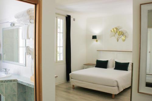 a bedroom with a bed and a sink and a tub at Hôtel Beau Site - Cap d'Antibes in Antibes