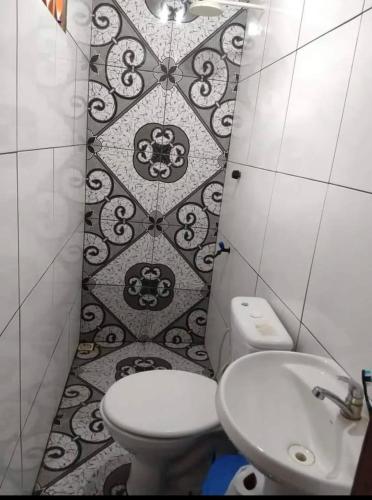 a bathroom with a toilet and a sink at Suítes em Parintins in Parintins