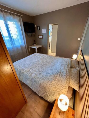 a bedroom with a bed with a white comforter at Studio proche RN145 Chez Greg in Saint-Sulpice-le-Guérétois