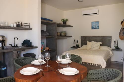a room with a table with wine glasses and a bed at Las 3 Carabelas BCS in El Sargento