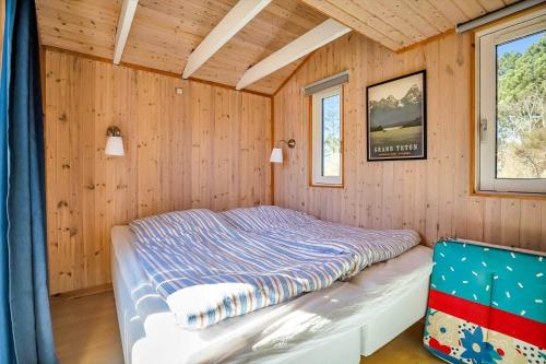 a bedroom with a bed in a wooden room at 16669-Farevejle-Alfestien-52 in Fårevejle