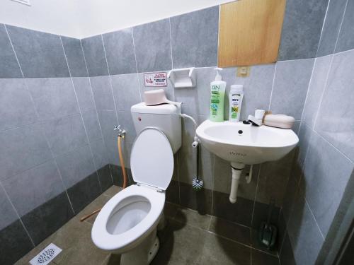 a bathroom with a toilet and a sink at Cozystayz NuNa in Sitiawan