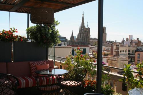 a balcony with a table and chairs and a view of the city at Kimpton Vividora Hotel by IHG in Barcelona