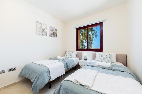 a bedroom with two beds and a window at Ribera Beach in Los Alcázares