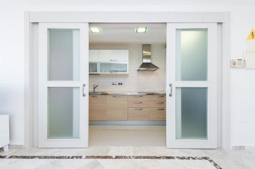 an open door leading to a kitchen with wooden cabinets at Ribera Beach in Los Alcázares