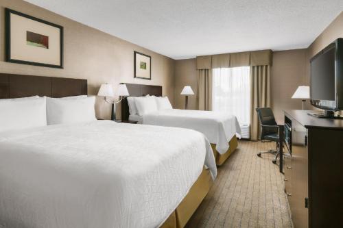a hotel room with two beds and a television at Garner Hotel Brockton - Boston by IHG in Brockton