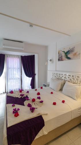 a bedroom with a large bed with red flowers on it at Aydos Hotels & Breeze Restaurant in Dalyan