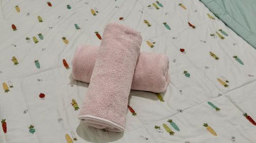 a pair of pink towels laying on a bed at The Podium, Kuching in Kuching