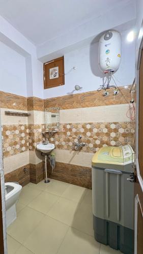 a bathroom with a toilet and a sink at The Raulane Homestay in Kalpa