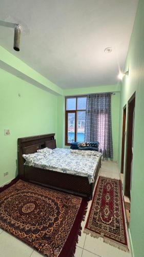 a bedroom with a bed and a window and a rug at The Raulane Homestay in Kalpa