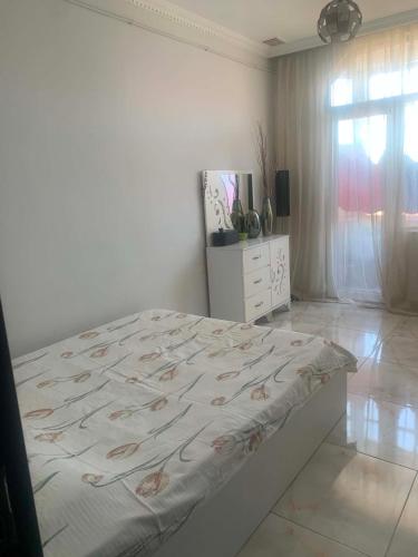 a bedroom with a bed and a dresser and a window at Memed abashidzis 16 in Kobuleti