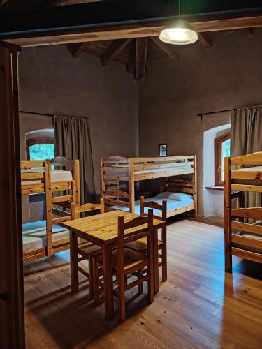 a room with a table and chairs and bunk beds at Rifugio Forte di Machaby in Arnad