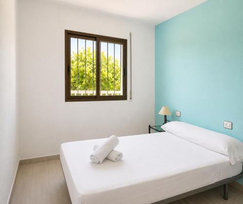 a white bedroom with a bed with a window at TARONGERS 7 in Peniscola