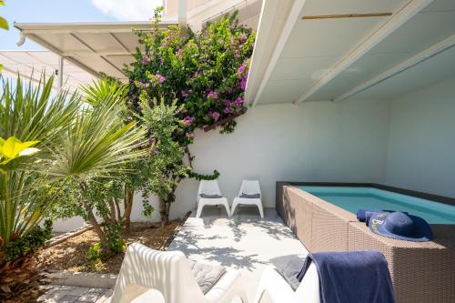 a patio with two chairs and a swimming pool at Villa Victoris Beachfront Luxury Villa with Heated Spa Pool Podstrana in Podstrana