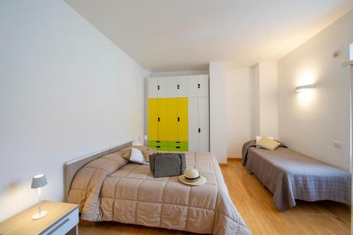a bedroom with two beds and a yellow wall at Casa Olimpo in Agerola