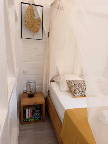 a small bedroom with a bed with a canopy at Bungalow la tipik in Saint-François