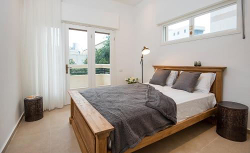 1 dormitorio con cama de madera y ventana en Reines5 TLV, en Tel Aviv