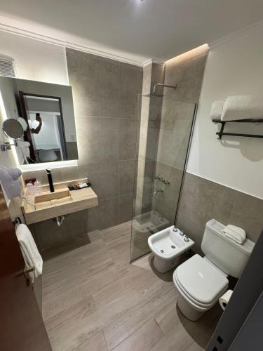 a bathroom with a toilet and a sink and a shower at Hotel República in Villa María