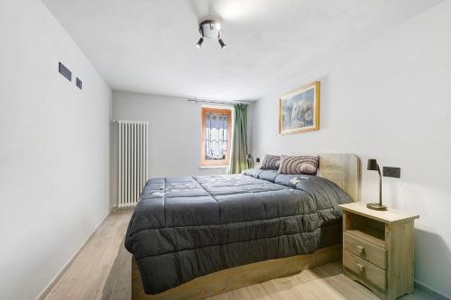 a bedroom with a bed and a table with a lamp at Lueur de la Rouja in Champoluc
