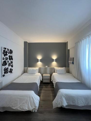 a row of four beds in a room at Hotel República in Villa María