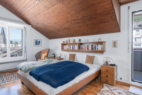 a bedroom with a large bed with a wooden ceiling at Charming Alpine Apt with View 5min to Interlaken Ost in Interlaken