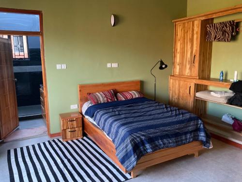 a bedroom with a bed with a striped comforter at Buye Holiday House in Mwanza