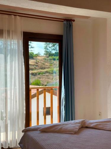 a bedroom with a bed and a window with a view at Villa Nature in Kırıkyayla