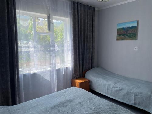 a bedroom with two beds and a window at Guest House Olga in Kaji-Say