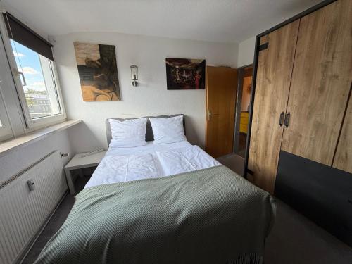 a bed in a small room with a window at Apartment Schmachtendorf in Oberhausen