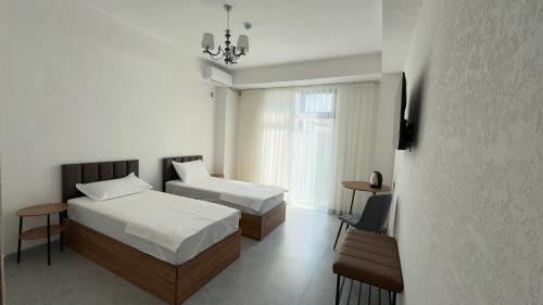 a hotel room with two beds and a window at Humor Hotel in Tashkent