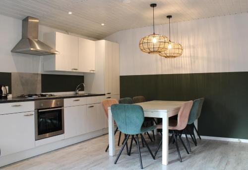 a kitchen with a dining table and chairs at Boslodge 7 personen in Tiendeveen