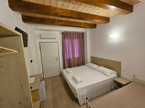 a bedroom with a white bed and a window at Country House Andromeda in Offida