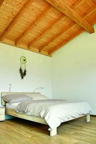 a bedroom with a bed with a wooden ceiling at La Boutique in Saignelégier