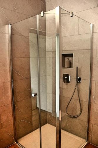 a shower with a glass door in a bathroom at La Boutique in Saignelégier