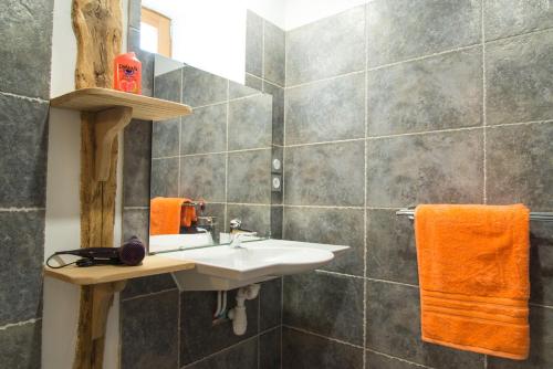 a bathroom with a sink and orange towels at L'etable de pierre in Nojaret