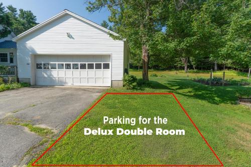 a yard with a garage with a sign for parking for the dairy double room at Dancing Light Farm in Bridgton