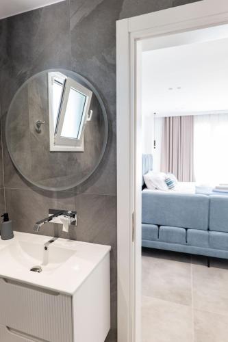a bathroom with a sink and a blue couch at Vila Antonio in Ksamil