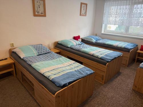 three bunk beds in a room with a window at Penzion Hedvika in Kravaře
