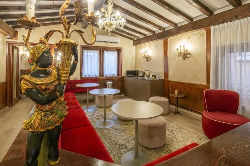 a living room with a red couch and a statue at Hotel Falier in Venice