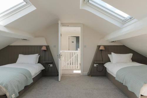 two beds in a attic room with skylights at The Roost in Westport