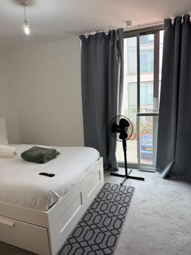 a bedroom with a white bed and a window at Cozy One bedroom with Free Underground parking in Mailbox Birmingham city in Birmingham