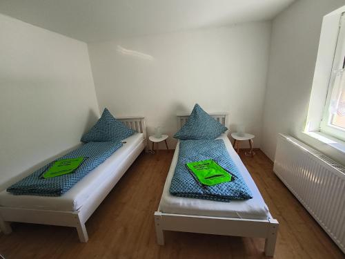two beds in a small room with two tables at Ferienwohnungen Ilona Blick in Kelberg
