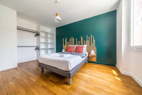 a bedroom with a bed and a green wall at Le Balcon Gaillard in Brive-la-Gaillarde