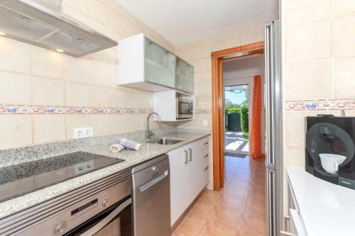 a kitchen with a sink and a microwave at Villa Jaume in Cala en Bosc