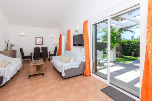 a living room with a bed and a sliding glass door at Villa Jaume in Cala en Bosc