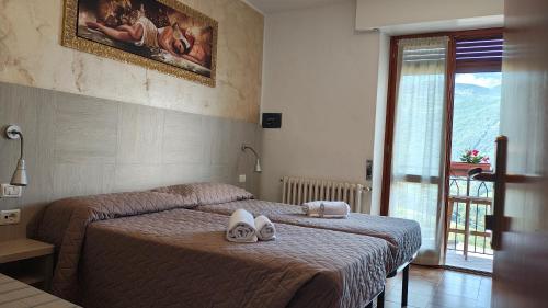 a bedroom with two beds with shoes on them at Hotel Posta in Rota d'Imagna